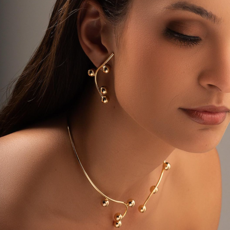 Semijoias para festas de fim de ano, modelo usa colar e brinco de ouro delicado minimalista dourado com formas organicas